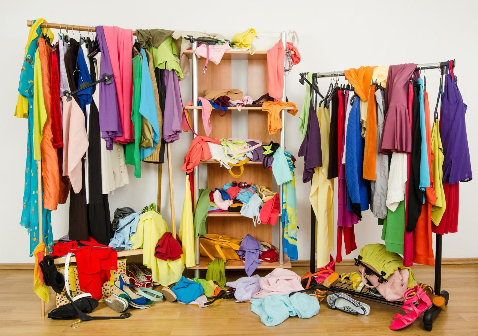 A photo of messy clothing strewn about on shelves